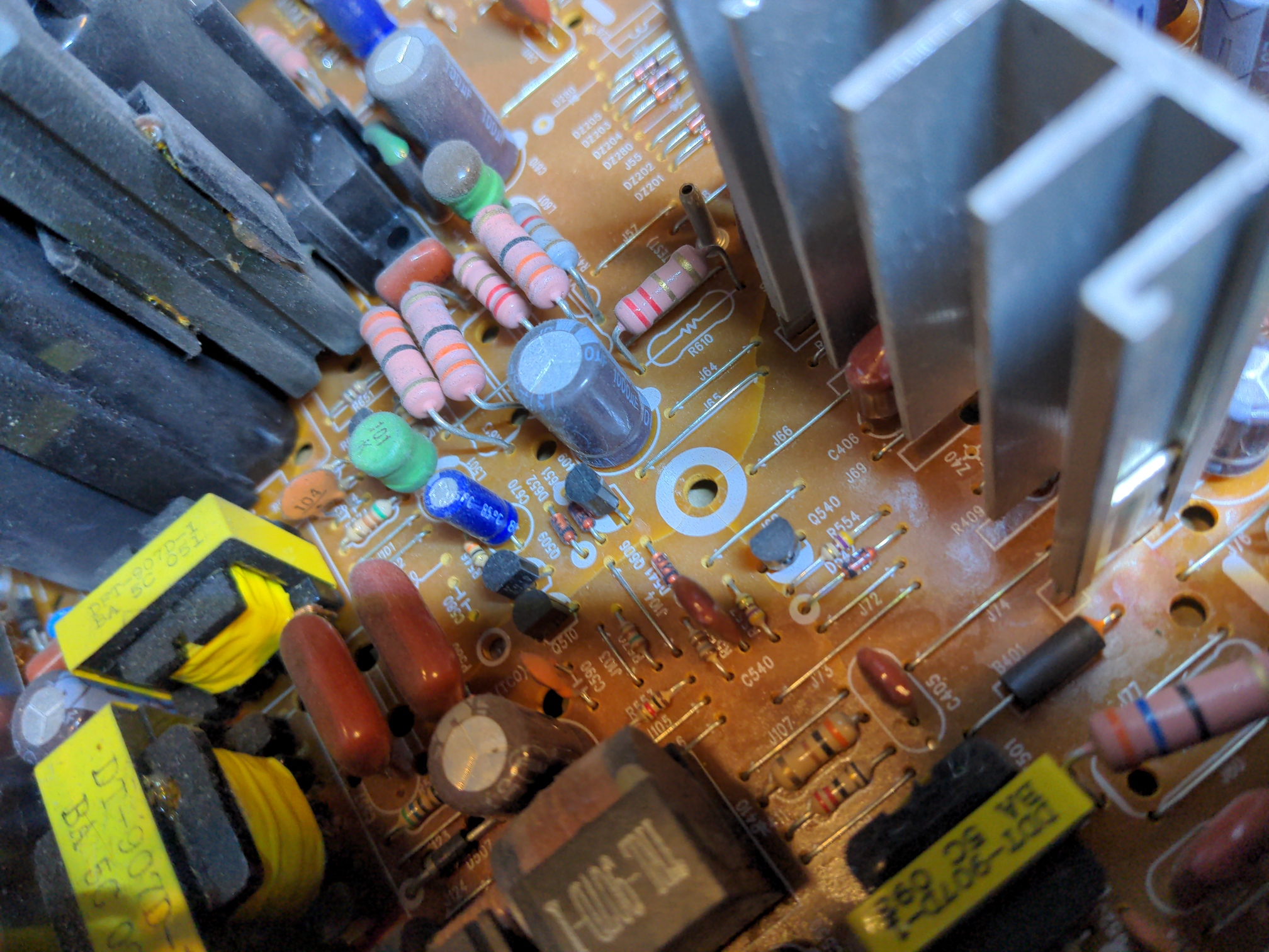 Closeup of a CRT control board, with damage visible around a mounting hole. The board is cracked, although it's hard to tell from this angle how far the cracks run since components are in the way.