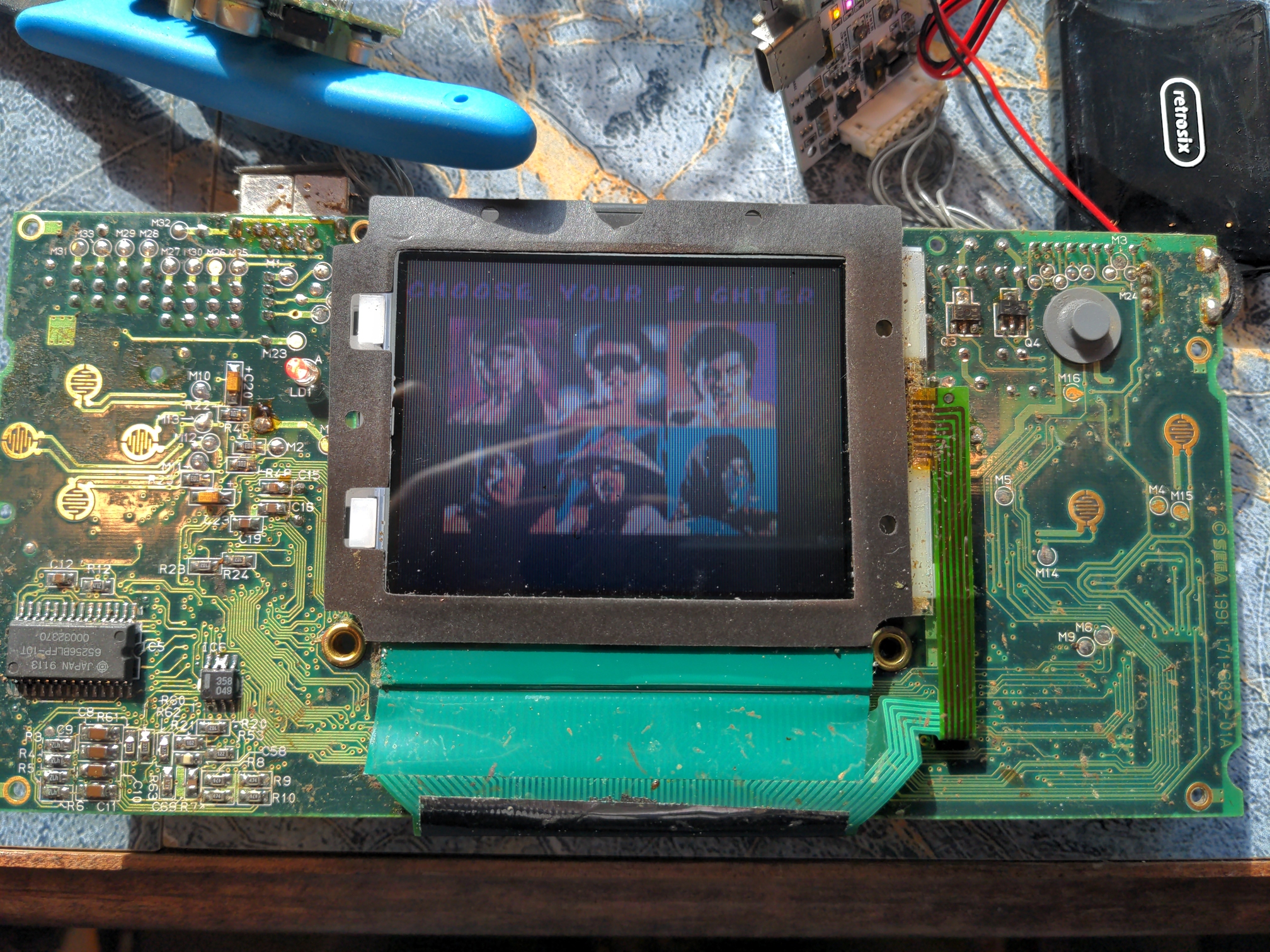 The main board of a Sega Game Gear, removed from the shell. The original LCD is still installed, and a number of visual imperfections are visible.